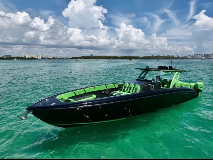  Yacht Photos Pics Midnight Express 2020 model boat with green accents on turquoise water under a blue sky.
