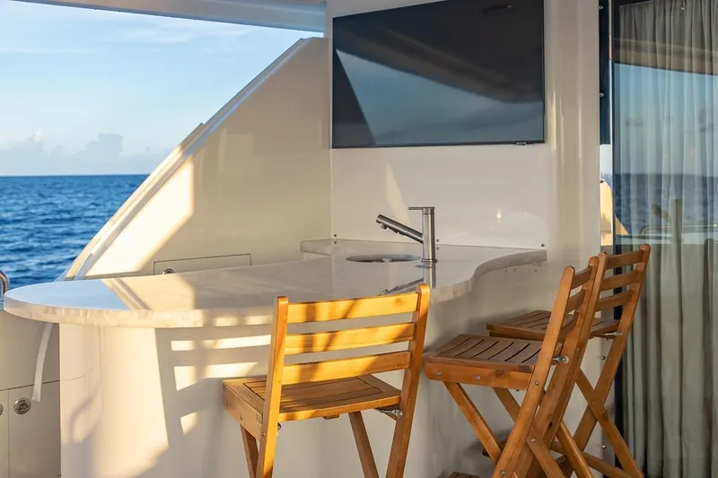 Kemosabe Yacht Photos Pics Luxurious yacht bar area on 2007 Westport 112, featuring ocean view and wooden chairs.