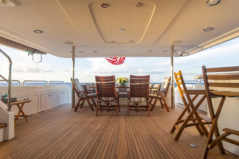 Kemosabe Yacht Photos Pics Luxurious 2007 Westport 112 yacht deck with wooden chairs and ocean view.