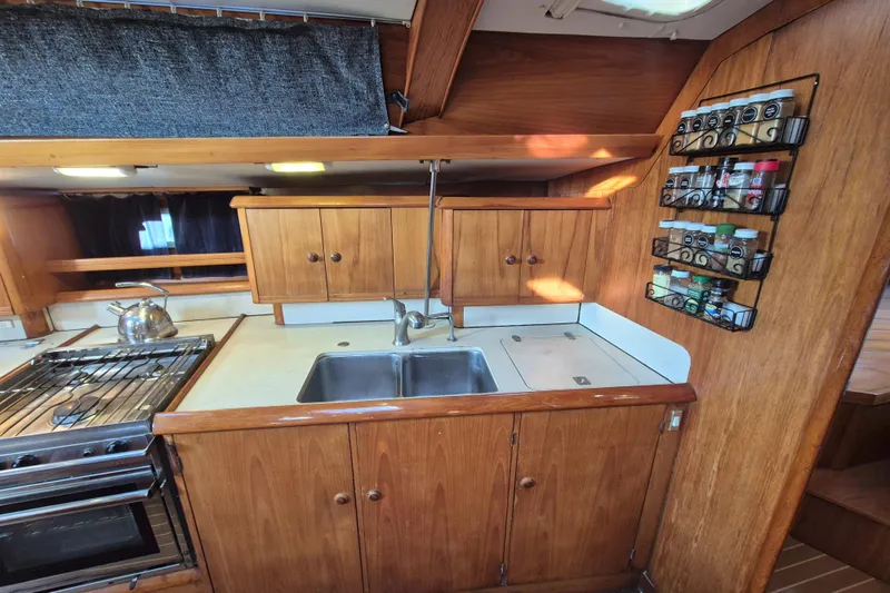 Time Warp Yacht Photos Pics Galley kitchen in 2000 Jeanneau Sun Odyssey 45.2 sailboat with wooden cabinetry.