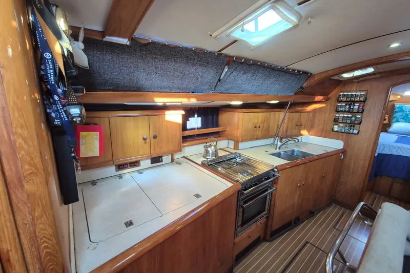 Time Warp Yacht Photos Pics Interior of 2000 Jeanneau Sun Odyssey 45.2 yacht kitchen with wooden cabinetry and appliances.