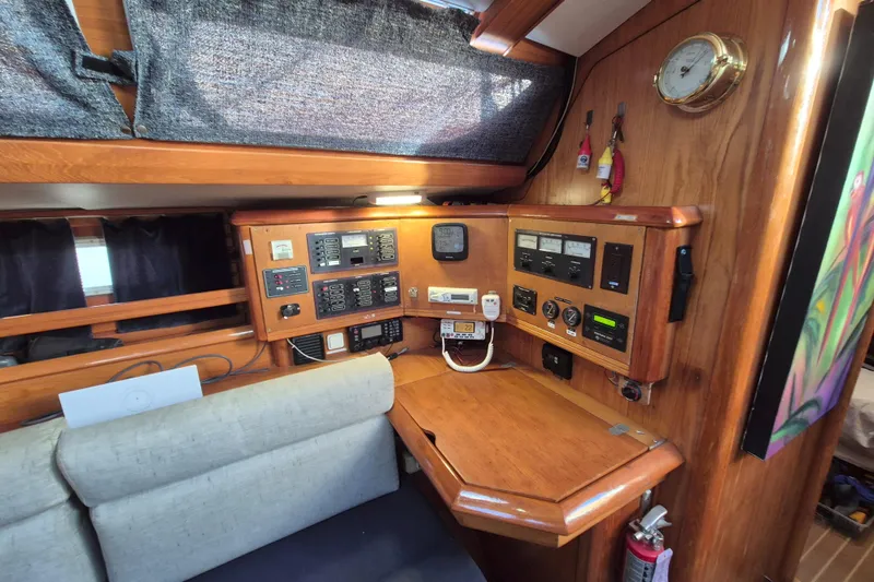 Time Warp Yacht Photos Pics Navigation station of 2000 Jeanneau Sun Odyssey 45.2 with control panels and wooden finish.