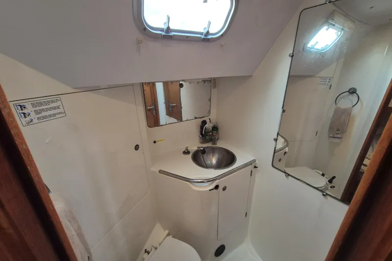 Time Warp Yacht Photos Pics Bathroom interior of 2000 Jeanneau Sun Odyssey 45.2 yacht, featuring sink and mirror.