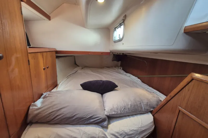 Time Warp Yacht Photos Pics Cozy cabin interior of 2000 Jeanneau Sun Odyssey 45.2 sailboat with bed and wooden storage.