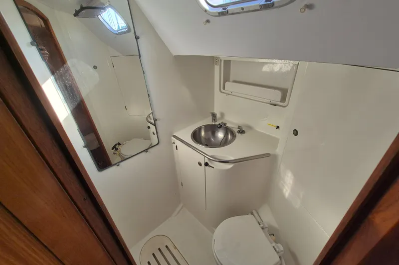 Time Warp Yacht Photos Pics Compact bathroom in a 2000 Jeanneau Sun Odyssey 45.2 sailboat, featuring a sink and toilet.