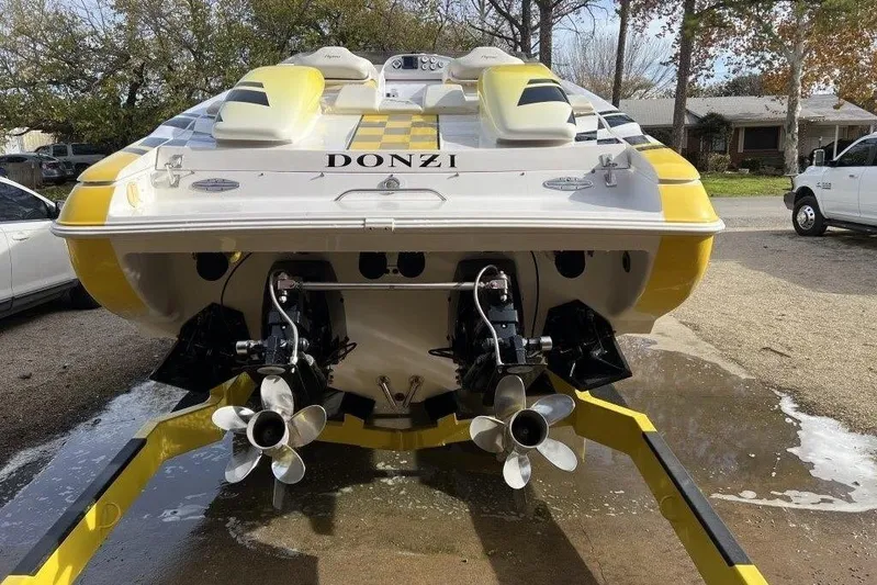  Yacht Photos Pics 2002 Donzi 38 Daytona boat with dual propellers, yellow and white design, parked outdoors.