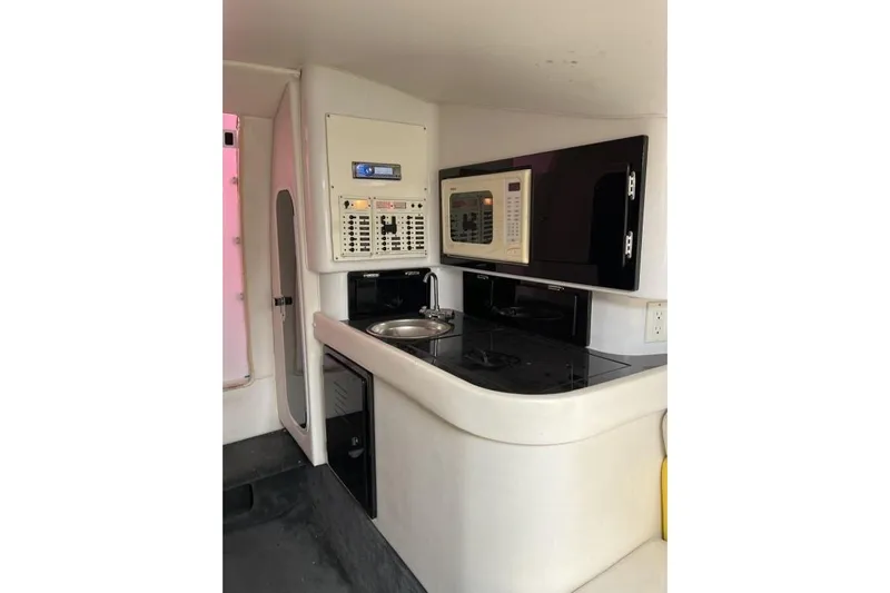  Yacht Photos Pics 2002 Donzi 38 Daytona interior with kitchenette, featuring sink, microwave, and control panel.