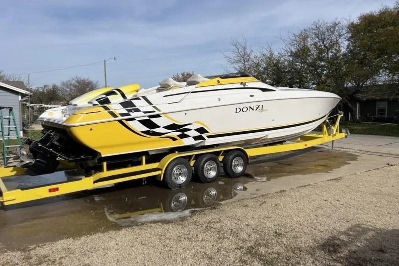  Yacht Photos Pics 2002 Donzi 38 Daytona powerboat on yellow trailer, featuring sleek design and vibrant graphics.