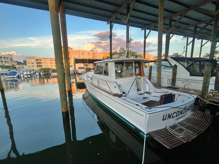 Unconquered Yacht Photos Pics 2002 Grand Banks 43 Eastbay HX docked in a marina at sunset.