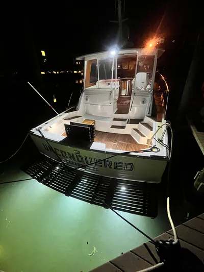 Unconquered Yacht Photos Pics 2002 Grand Banks 43 Eastbay HX yacht illuminated at night, docked with underwater lights.