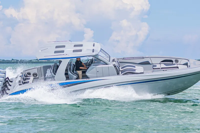  Yacht Photos Pics 2023 Deep Impact 399 Sport boat cruising on clear water under a blue sky.