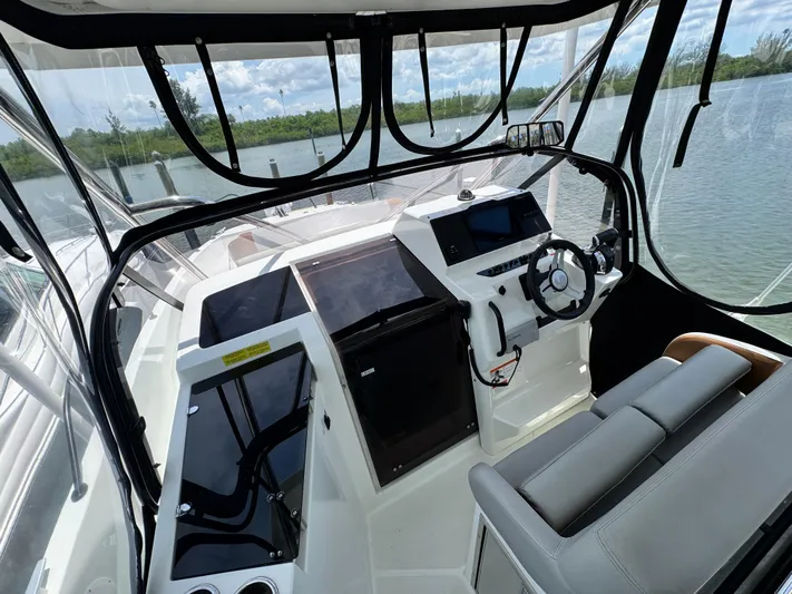  Yacht Photos Pics 2022 Beneteau Flyer 9 SUNdeck cockpit with modern controls and seating, overlooking serene waters.