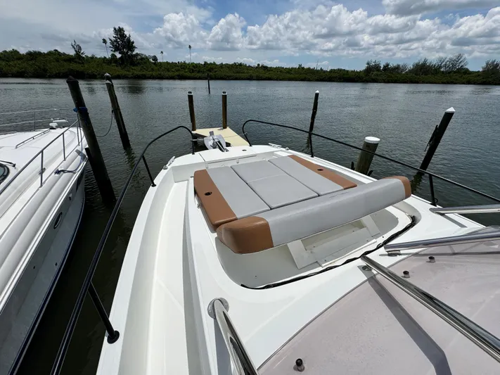  Yacht Photos Pics 2022 Beneteau Flyer 9 SUNdeck moored by a serene waterfront, showcasing its spacious deck.