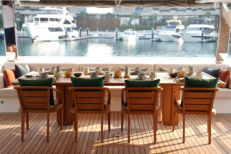 Geulunel Yacht Photos Pics Luxurious dining setup on 2025 Majesty 120 yacht with marina view.