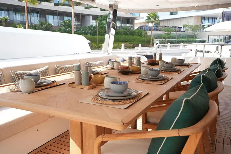 Geulunel Yacht Photos Pics Elegant dining setup on 2025 Majesty 120 yacht, featuring stylish tableware and comfortable seating.