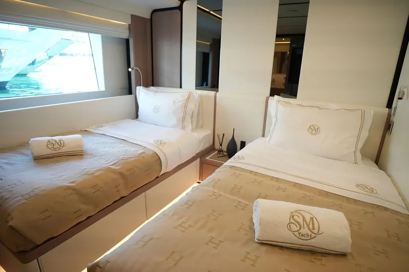 Geulunel Yacht Photos Pics Luxurious twin bedroom on 2025 Majesty 120 yacht with elegant bedding and window view.