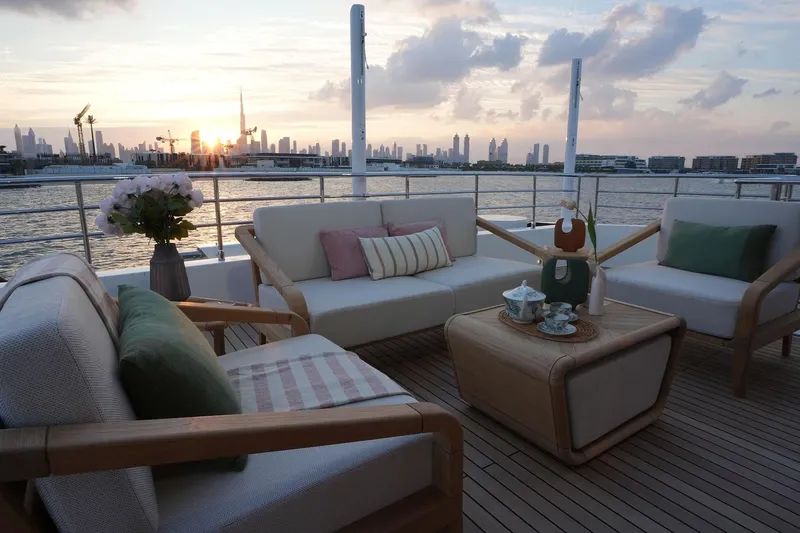 Geulunel Yacht Photos Pics Luxurious deck of 2025 Majesty 120 yacht with city skyline at sunset.