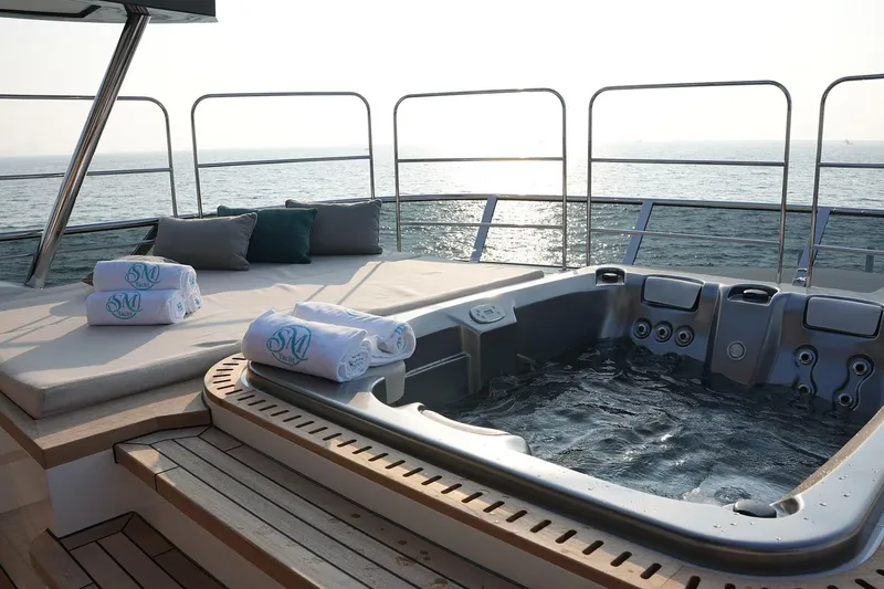 Geulunel Yacht Photos Pics Luxurious deck with jacuzzi on 2025 Majesty 120 yacht, overlooking serene ocean view.