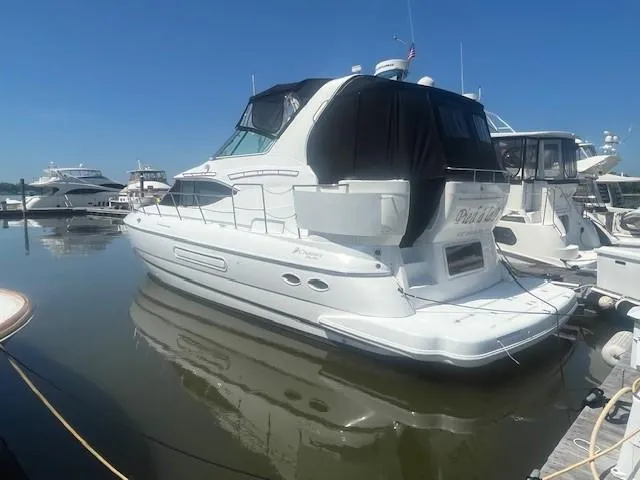  Yacht Photos Pics 2000 Cruisers Yachts 4450 Express Motoryacht docked in a marina under clear blue skies.