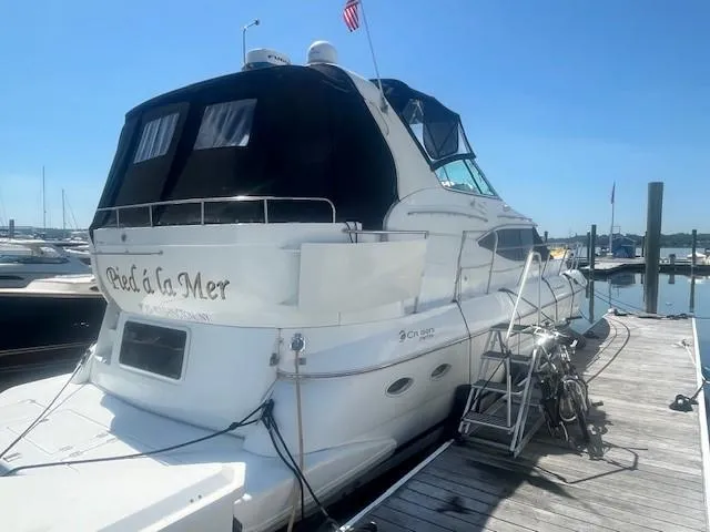  Yacht Photos Pics 2000 Cruisers Yachts 4450 Express Motoryacht docked at marina under clear blue sky.