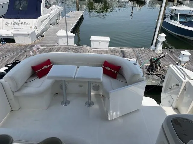  Yacht Photos Pics 2000 Cruisers Yachts 4450 Express Motoryacht with docked seating area and red cushions.