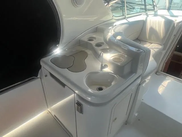  Yacht Photos Pics 2000 Cruisers Yachts 4450 Express Motoryacht interior with sink and seating area.