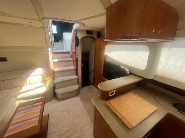  Yacht Photos Pics Interior of 2000 Cruisers Yachts 4450 Express Motoryacht, featuring cozy seating and modern kitchen area.