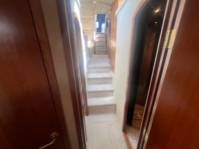  Yacht Photos Pics Interior hallway of 2000 Cruisers Yachts 4450 Express Motoryacht, featuring wooden doors and carpeted stairs.