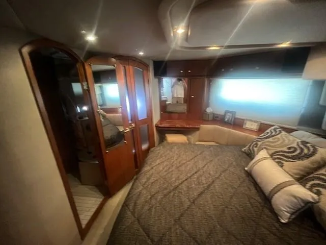  Yacht Photos Pics Luxurious bedroom interior of 2000 Cruisers Yachts 4450 Express Motoryacht with elegant wood finishes.