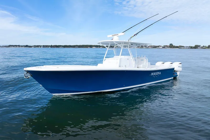 34 Ss Yacht Photos Pics 2018 Regulator 34SS boat on calm water, featuring a sleek blue hull and fishing rods.