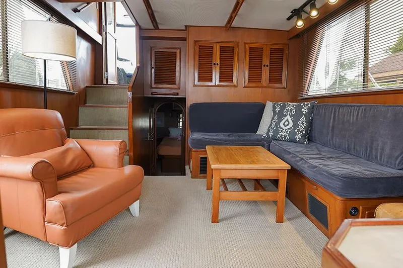Sunshine Yacht Photos Pics Interior of 1986 Marine Trader Tradewinds 47 yacht with cozy seating and wooden accents.
