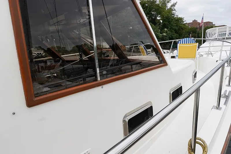 Sunshine Yacht Photos Pics 1986 Marine Trader Tradewinds 47 yacht, side view with windows and railing.