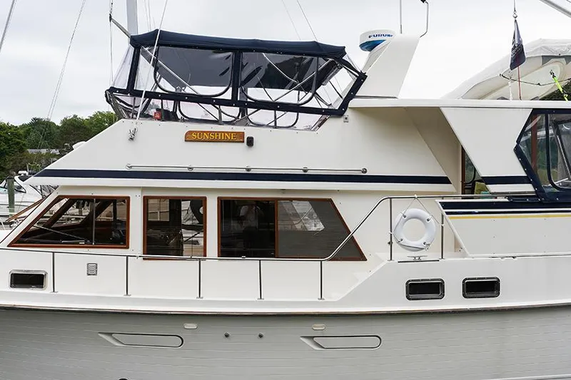 Sunshine Yacht Photos Pics 1986 Marine Trader Tradewinds 47 yacht docked, featuring a white exterior and upper deck canopy.