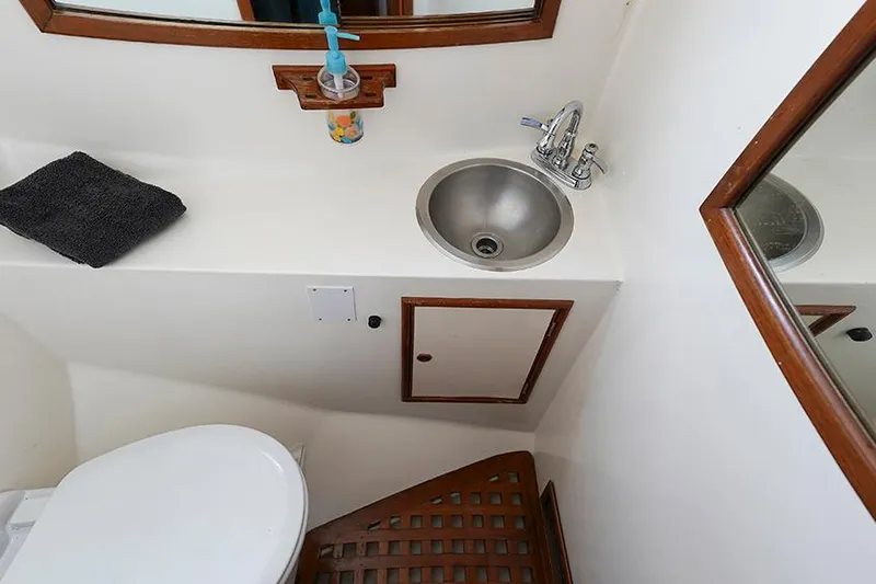 Sunshine Yacht Photos Pics Bathroom interior of 1986 Marine Trader Tradewinds 47 yacht with sink and toilet.