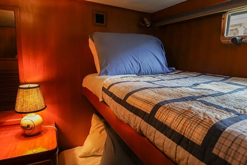 Sunshine Yacht Photos Pics Cozy cabin interior of 1986 Marine Trader Tradewinds 47 with bed and lamp.