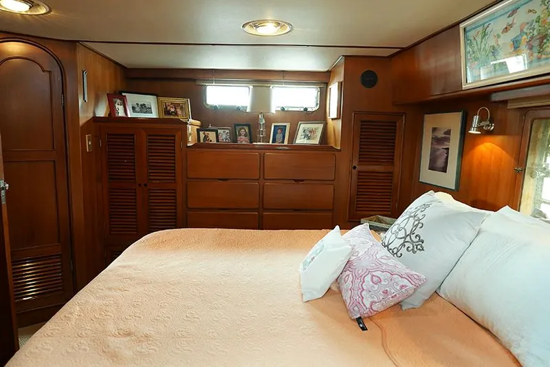 Sunshine Yacht Photos Pics Cozy bedroom in 1986 Marine Trader Tradewinds 47 yacht with wood paneling and decorative accents.