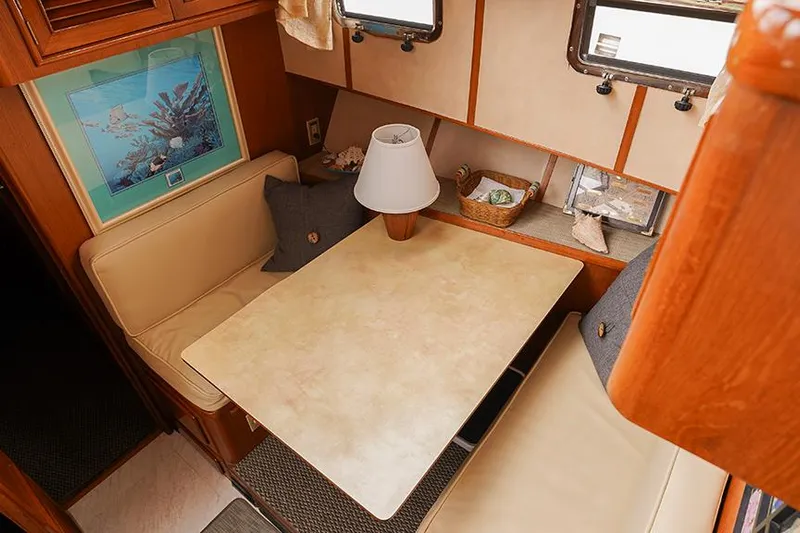 Sunshine Yacht Photos Pics 1986 Marine Trader Tradewinds 47 interior dining area with table, lamp, and seating.