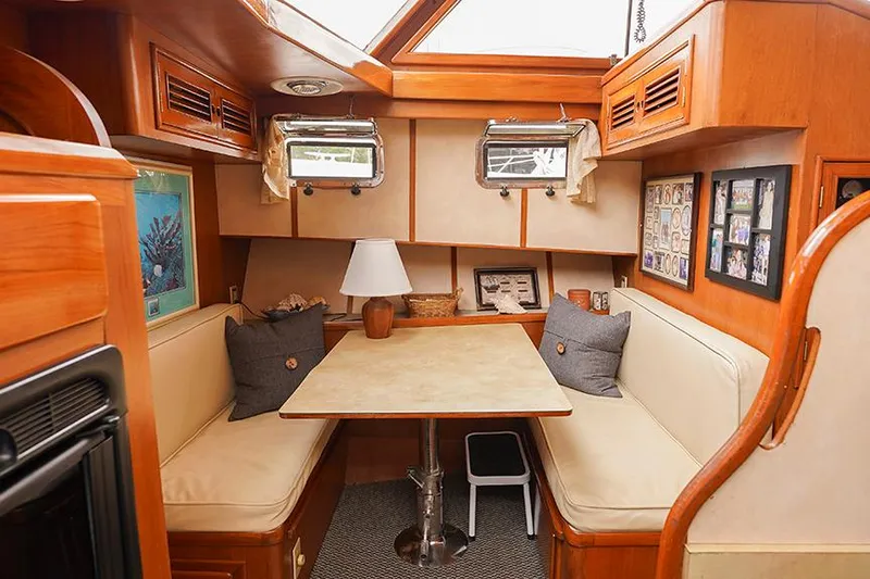 Sunshine Yacht Photos Pics 1986 Marine Trader Tradewinds 47 interior with cozy dining area and wooden accents.