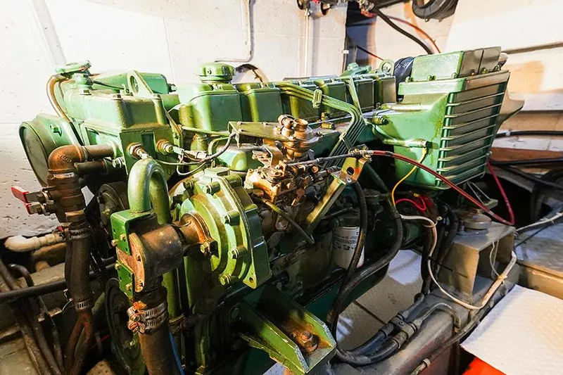 Sunshine Yacht Photos Pics Engine room of a 1986 Marine Trader Tradewinds 47, showcasing a green marine engine.