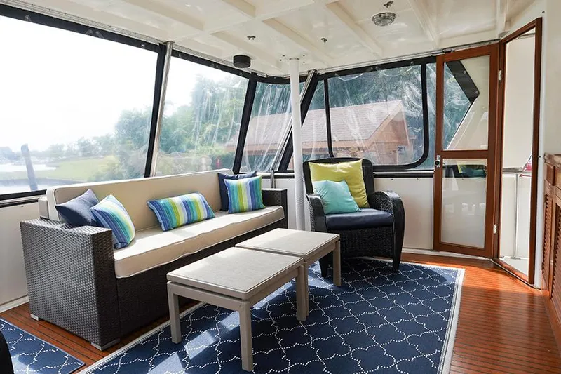 Sunshine Yacht Photos Pics Interior of 1986 Marine Trader Tradewinds 47 yacht with cozy seating and nautical decor.