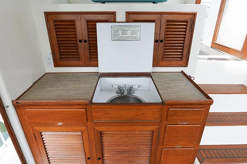 Sunshine Yacht Photos Pics 1986 Marine Trader Tradewinds 47 yacht interior with wooden cabinetry and built-in sink.