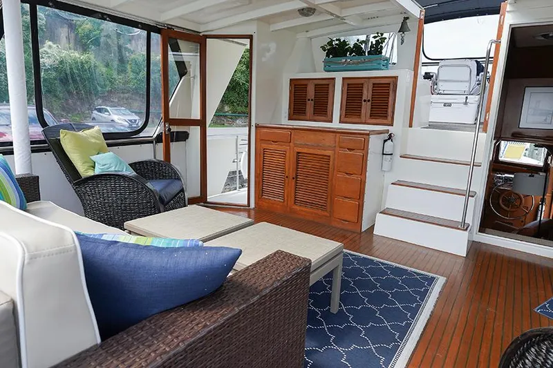 Sunshine Yacht Photos Pics Interior of 1986 Marine Trader Tradewinds 47 yacht with cozy seating and wooden cabinetry.