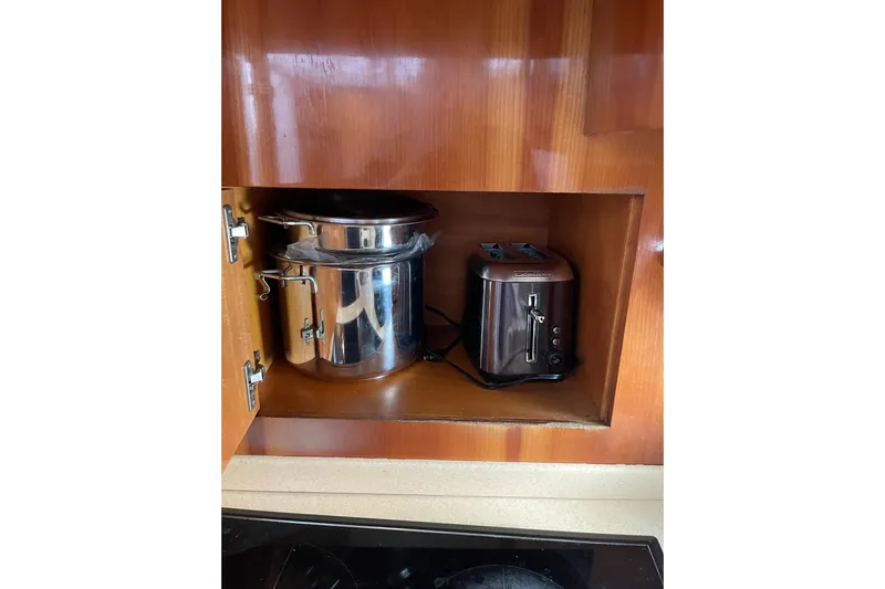 Offshore Flyer Yacht Photos Pics Kitchen cabinet with a stainless steel pot and toaster on Azimut 46 Flybridge MY, 2000.