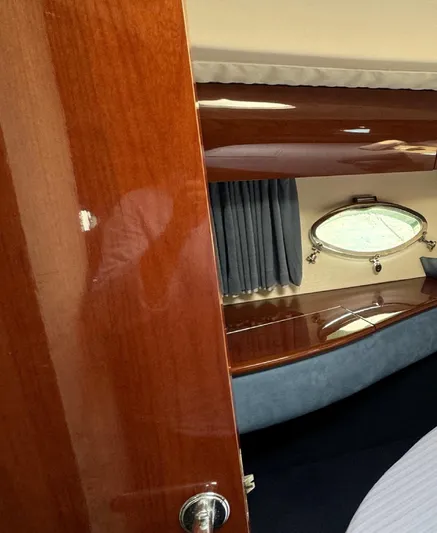  Yacht Photos Pics Interior of a 2004 Princess V65 yacht cabin with wooden finish and porthole.