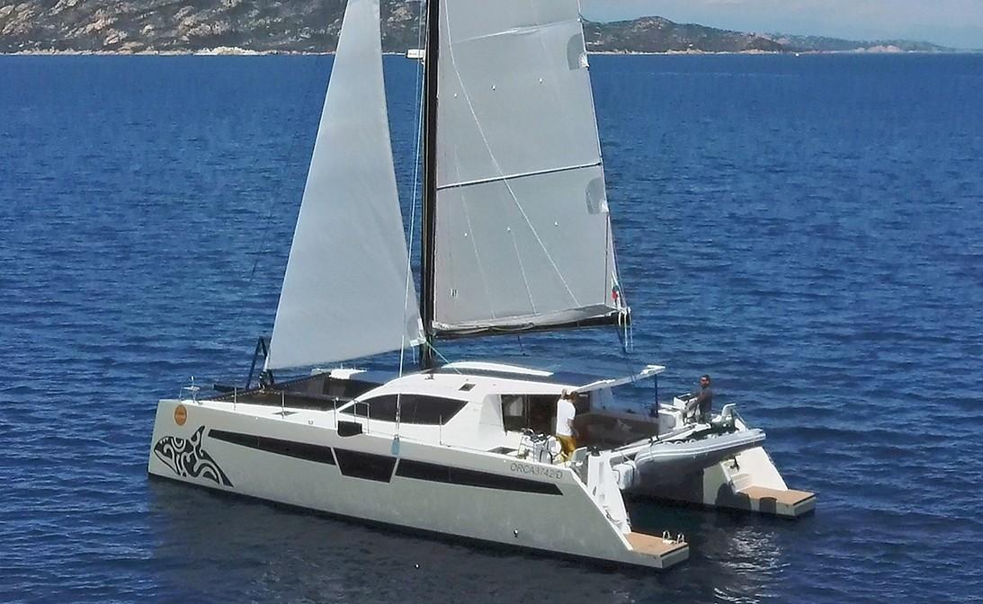 2025 Comar C-Cat 48 catamaran sailing on a calm blue sea.