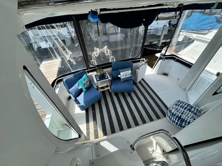 Carolina Breeze Yacht Photos Pics 2002 Carver 444 Cockpit Motor Yacht interior with seating area and striped rug.