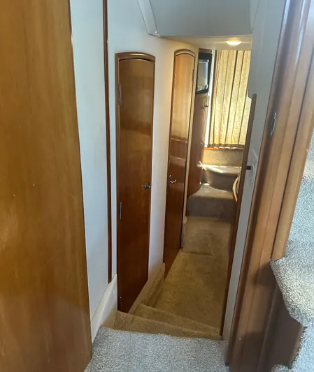 Carolina Breeze Yacht Photos Pics Interior hallway of 2002 Carver 444 Cockpit Motor Yacht with wooden doors and carpeted stairs.
