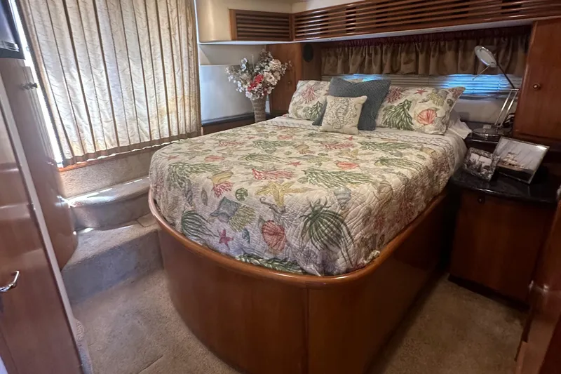 Carolina Breeze Yacht Photos Pics 2002 Carver 444 Cockpit Motor Yacht bedroom with floral bedding and wooden cabinetry.