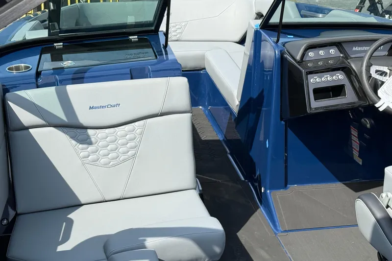  Yacht Photos Pics 2026 MasterCraft NXT24 boat interior with blue and gray seating and dashboard.