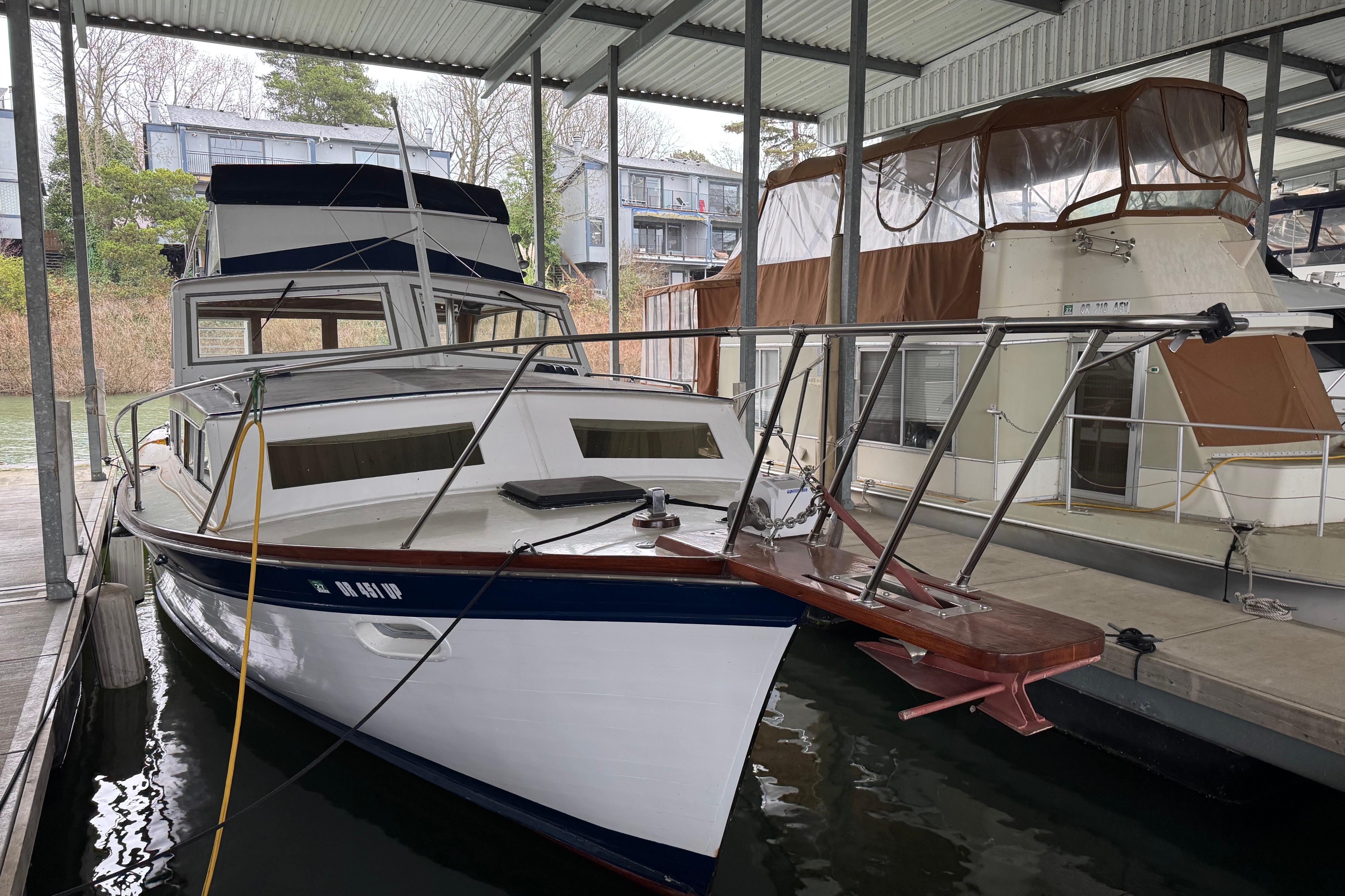 1967 Pacemaker 37 boat docked in a covered marina, surrounded by other vessels.